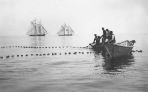old black and white photo of fishermen spreading their nets off island.