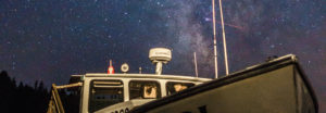 cropped image of lobster boat with the milky way in the background