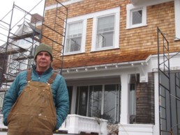 man standing in front of house with scaffolding