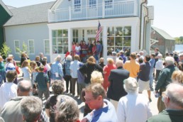 crowd standing in front of building at community center opening ceremony