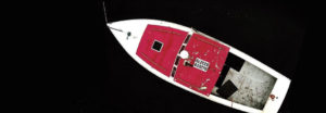 small red and white boat shot from above