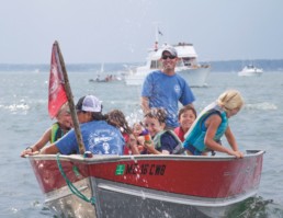 man and kids with water guns in small boat