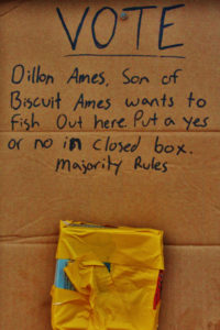 "Dillon Ames, son of Biscuit Ames wants to fish out here put a yes or no in closed box. majority rules" written in marker on piece of cardboard